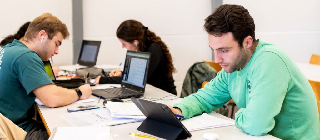 Alumnos estudiando con ordenadores portátiles en la Sala de la biblioteca