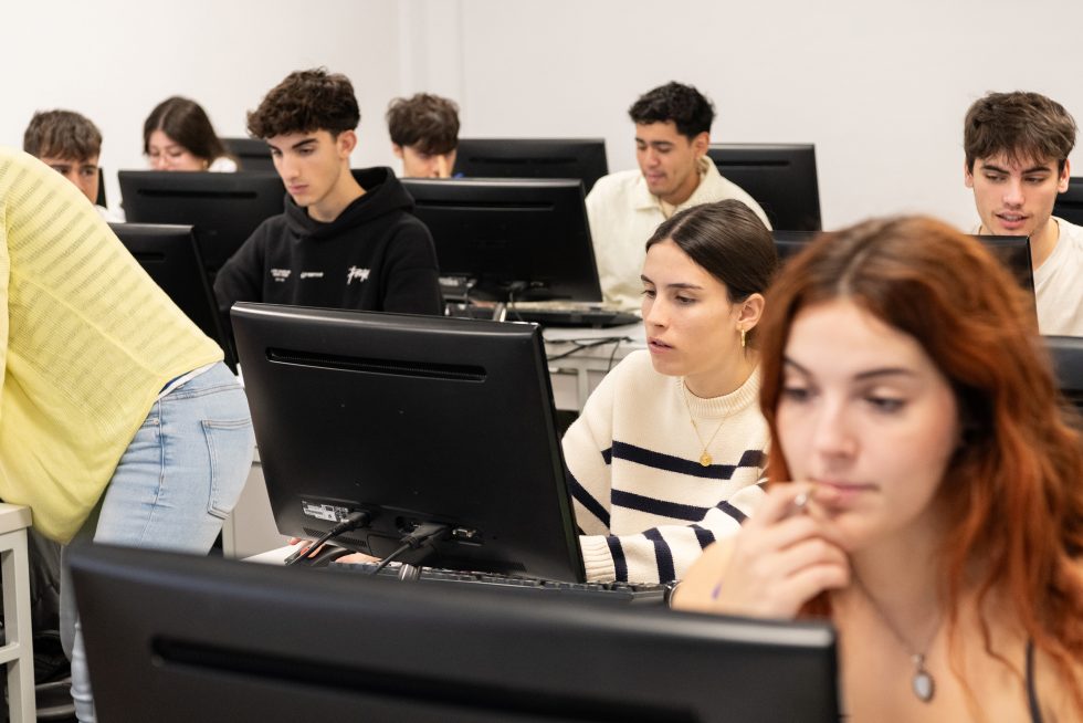 Alumnos en una clase con ordenadores